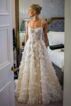 a woman in a wedding dress looking at herself in the mirror