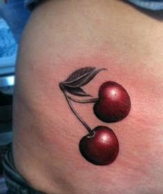 a woman's stomach with two cherries tattoo on her lower back and side