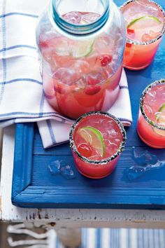 three glasses filled with watermelon and limeade on a blue tray