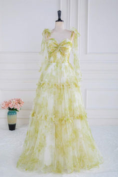 This alluring formal dress features yellow floral print fabric, a tulle A-line silhouette, sleeveless construction, a knotted front, tie shoulders, and a ruffled skirt. The dress features a zip-up closure at the back, making it full-length. Item #NP1063 Color: Yellow floral print Material: Tulle Silhouette: A-line Sleeves: Sleeveless Embellishment: knotted front, tie shoulders, ruffles skirt Back: Zip-up back Length: Full length Fully lined: Yes Built-in bra: Yes True to size. Made in China. Dre Light Green Prom Dress, Tulle Long Prom Dress, Yellow Bow Tie, Tulle Material, Floral Prom Dresses, Prom Dresses Yellow, Floral Bow Tie, Floor Length Skirt, Tulle Gown