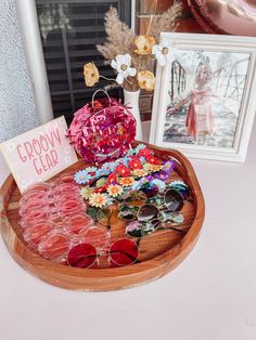 a wooden tray with sunglasses and a sign on it that says goodbye clar next to some pictures