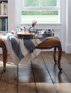 a table that has some food on it in front of a window with bookshelves