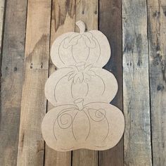 a paper cut out of a pumpkin sitting on top of a wooden floor