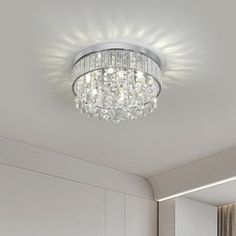 a white bedroom with a chandelier hanging from the ceiling