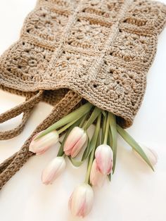 a crocheted bag with tulips on the side