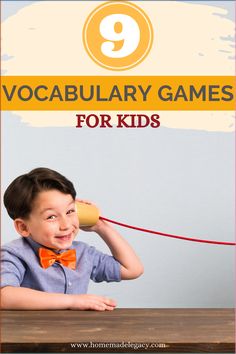 a young boy is talking on the phone while sitting at a table with an orange bow tie