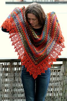 a woman is standing outside with her hands on her hips wearing a colorful shawl