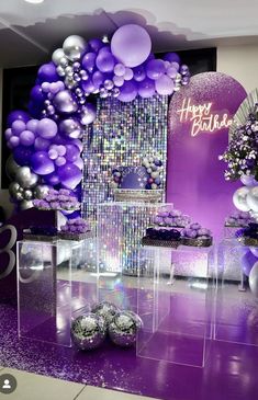 purple and silver balloons are on display in front of a wooden wall at a wedding