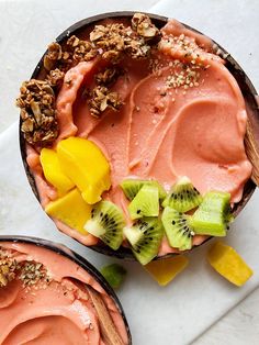 two bowls filled with fruit and nuts on top of a white countertop next to each other