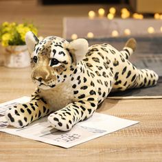 a stuffed leopard laying on top of a table