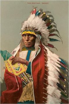 an old photo of a native american man wearing feathers and headdress, holding a drum