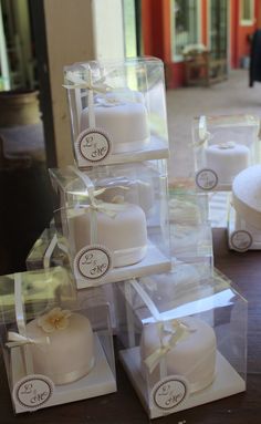 several small white cakes in clear boxes on a table