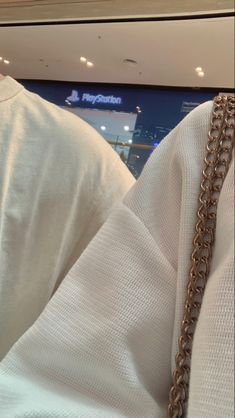 a close up of a person wearing a white shirt with a chain around their neck