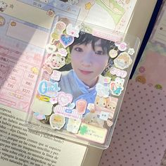 an open book with pictures and stickers on the pages, along with other items