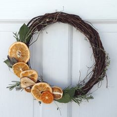 a grapevine wreath with orange slices and leaves