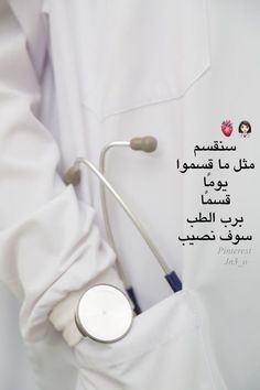 a doctor in white coat holding a stethoscope with arabic writing on it