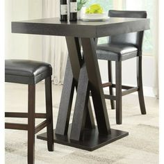 a dining room table with two chairs and a wine bottle