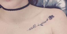 a woman's chest with the words still rise on it and a rose tattoo