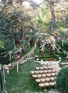 an image of a wedding setup in the middle of a yard with chairs and flowers