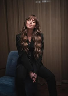 a woman sitting on top of a blue chair