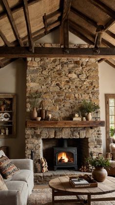 a living room filled with furniture and a fire place in the middle of a stone fireplace