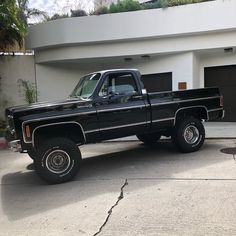 a black pickup truck parked in front of a house