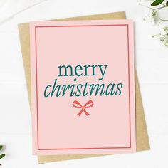 a pink christmas card with the words merry christmas on it and a bow in front