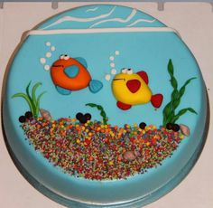 there is a cake decorated to look like a fish in the water with bubbles and sprinkles