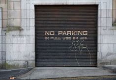 a garage door with graffiti on it that says no parking in full use