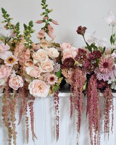 several different types of flowers are arranged on a mantle