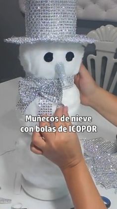 someone is decorating a snowman with silver sequins