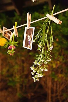 flowers hanging from clothes line with pictures on them