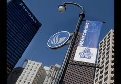 a street sign on a pole in front of some tall buildings and a blue sky