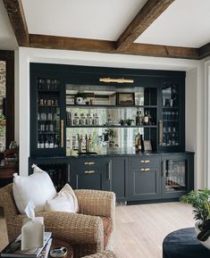 a living room filled with furniture and lots of bottles on top of the shelves in front of it