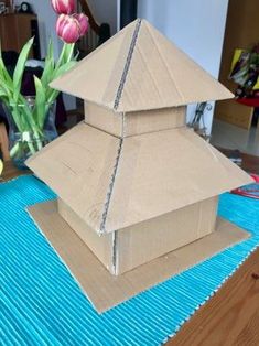 two cardboard boxes are stacked on top of each other, with flowers in the background