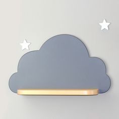 there is a cloud with stars on the wall above it and a shelf below it