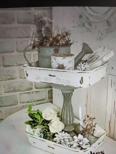 there is a white tray with flowers and plants in it on top of a table