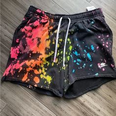 a pair of shorts with colorful paint splattered on them