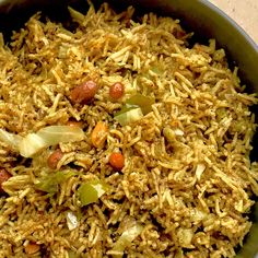 a bowl filled with rice and vegetables on top of a table