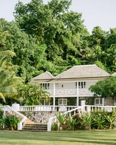 a white house surrounded by lush green trees