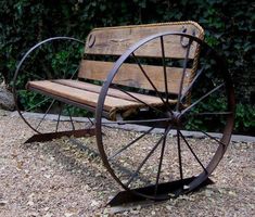 a wooden bench sitting on top of a gravel ground