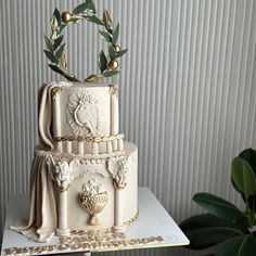 a three tiered cake with an olive wreath on top