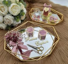 two mirrored trays with flowers and perfume bottles on them sitting on a fur surface