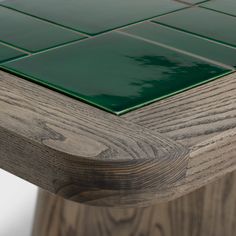 a wooden table with green tiles on it's top and bottom edge, viewed from the side