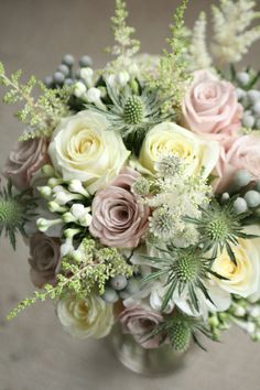 a vase filled with lots of flowers on top of a table