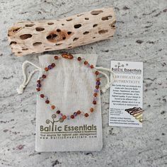 a bag with a beaded bracelet on it next to a piece of driftwood