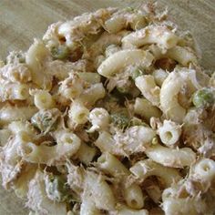 a bowl filled with macaroni salad sitting on top of a wooden table