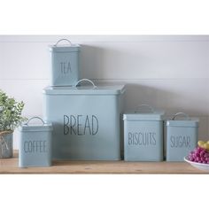 three blue canisters with the words bread, biscuits, sugar and tea on them