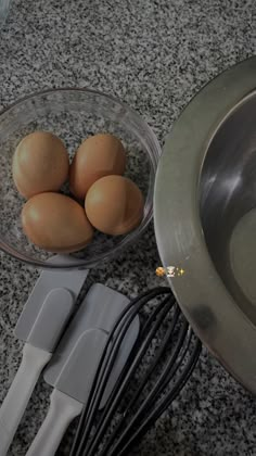 eggs and whisks in a bowl next to an electric mixer on a granite countertop