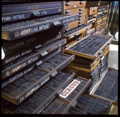 there are lots of boxes stacked on top of each other in the store, and one has a sign that says egyptian antiques